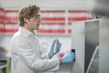 男实验人员在缝线厂将实验室样品放在化学烤箱中图片