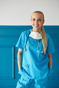 女外科医生身穿手术防护服插兜微笑图片