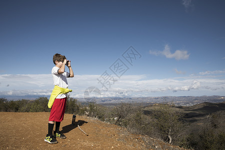 在美国加利福尼亚州千橡树山丘用相机探险的男孩背景图片