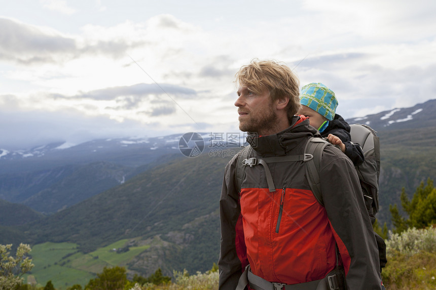 挪威奥普兰州洛美公园山地背着孩子的男远足者图片