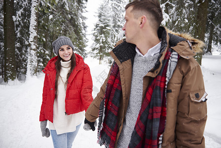 在雪中行走的年轻夫妇围巾高清图片素材