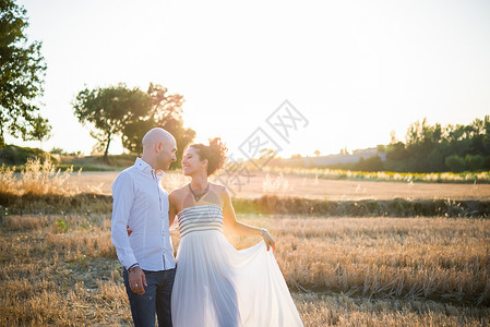 夫妇站在田野面对面微笑图片