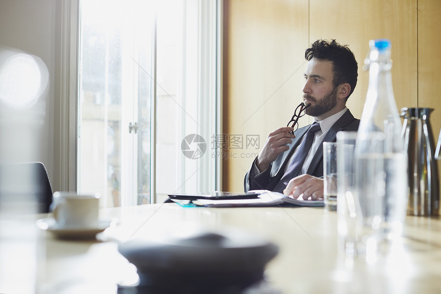 商人在会议室桌子上思考图片