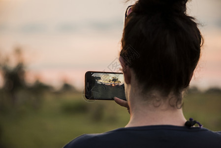 非洲博茨瓦纳奥卡万戈三角洲年轻女子用手机拍照高清图片
