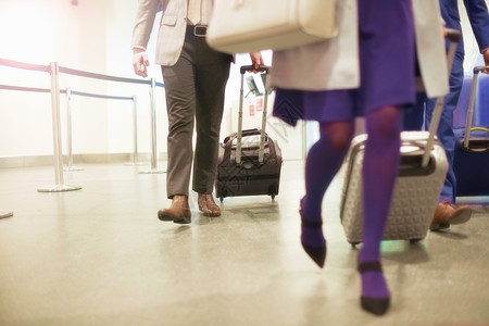 机场的男女商人拉着行李箱在走图片