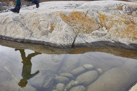 湖边的男孩走在岩石上的倒影白天高清图片素材