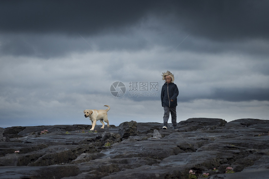 带宠物拉布多犬的岩石上小男孩爱尔兰克拉雷杜林图片