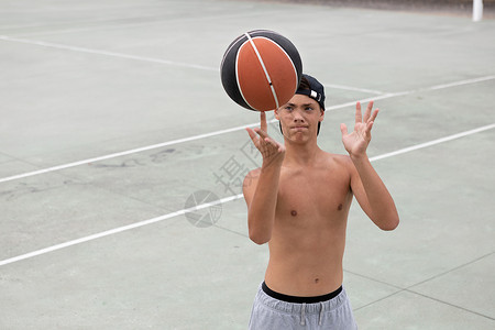 男青少年篮球运动员在场上手指打滚球图片