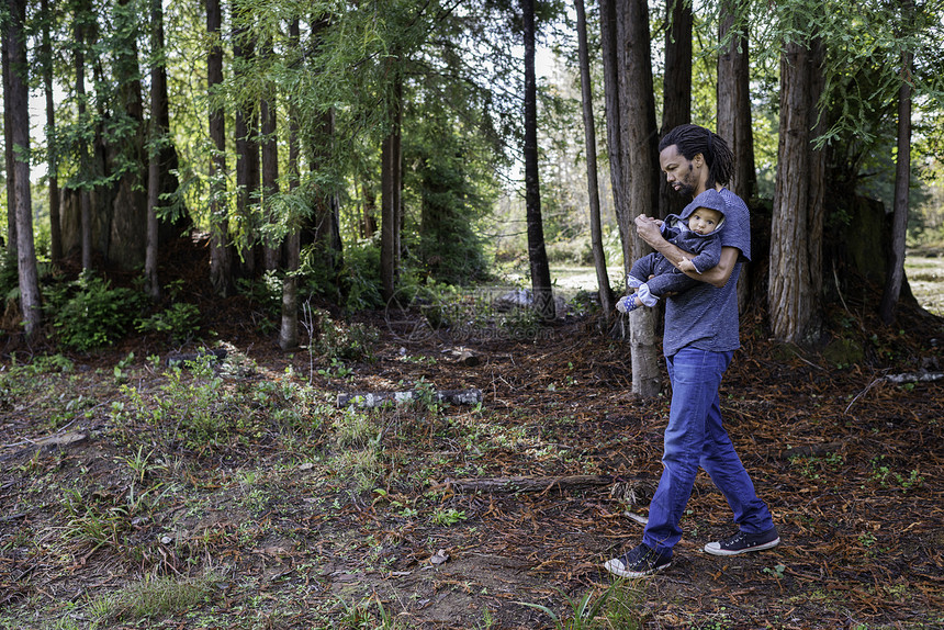成年男子在森林中漫步带着婴儿子图片