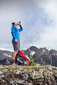 美国科罗拉多州欧莱斯内弗勒山把包放在脚下喝水的登山者图片
