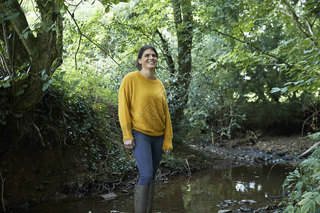 在溪流中站着微笑的女人图片