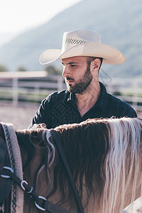 牛仔在骑马竞技场上检查背景图片