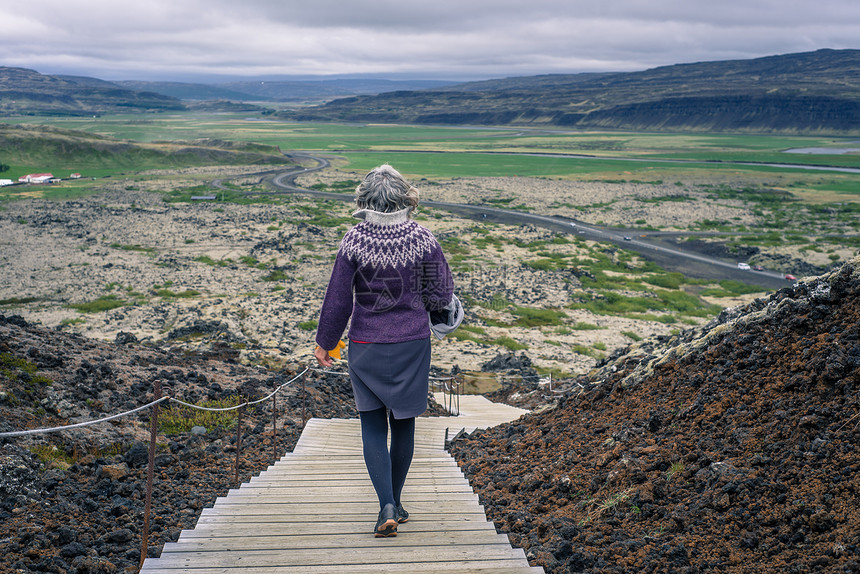 环绕冰岛格拉布罗克火山栈道上的女人背影图片