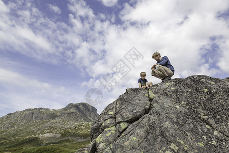 男孩和父亲在岩石上学习图片
