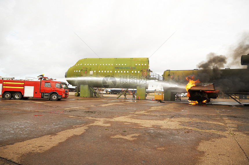 消防员培训在模拟飞机上喷洒消防水图片