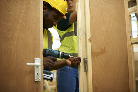 男学生在大讲习班上钻木制门道图片