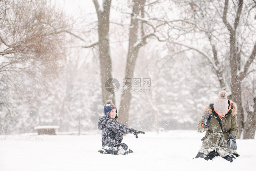 男孩向姐妹扔雪球图片