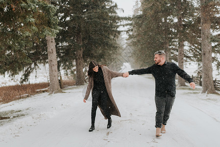 在加拿大乔治敦的雪地上牵手行走的情侣白天高清图片素材
