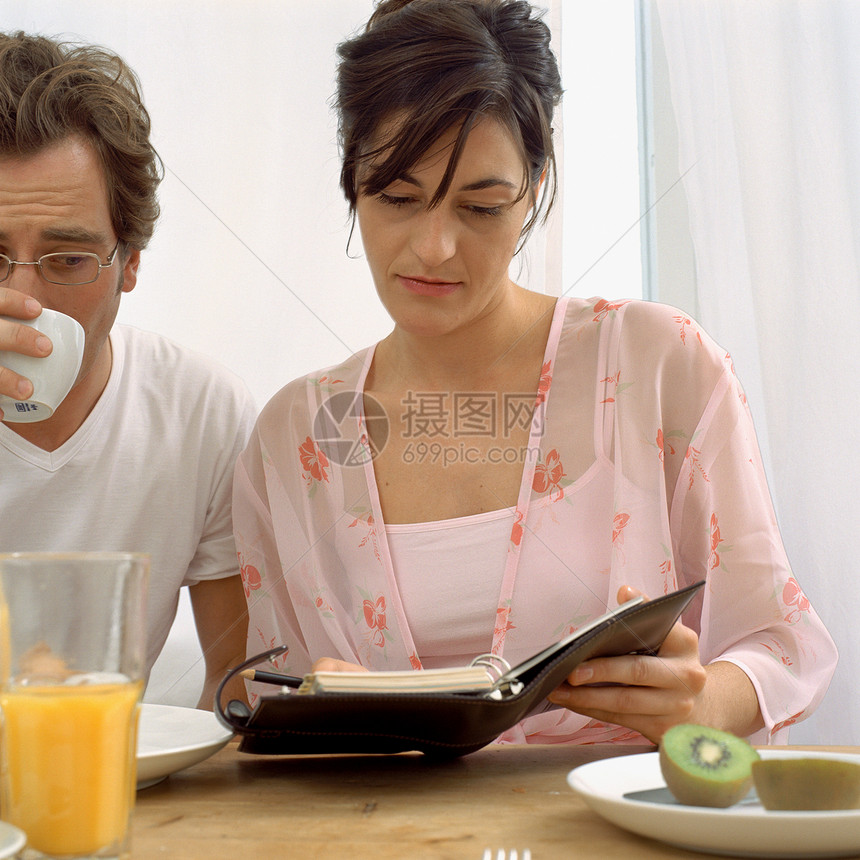 早餐时看记事簿的夫妻图片