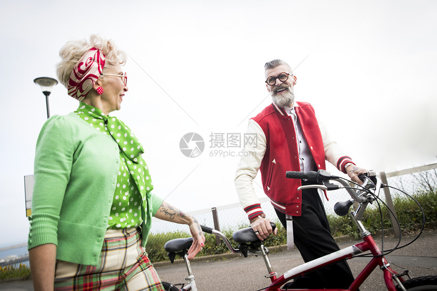 打扮复古的老年夫妻在海岸骑自行车图片