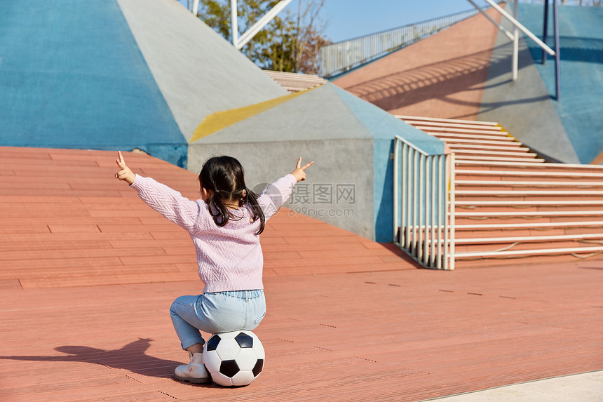 小女孩在户外玩耍踢足球背影图片