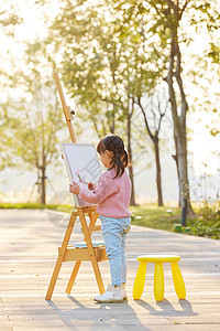 假期在户外玩耍画画的小女孩背景图片