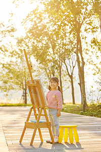 在户外郊游画画的小女孩背景图片