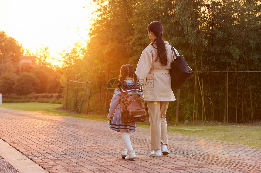 夕阳下妈妈接女儿放学回家背影图片