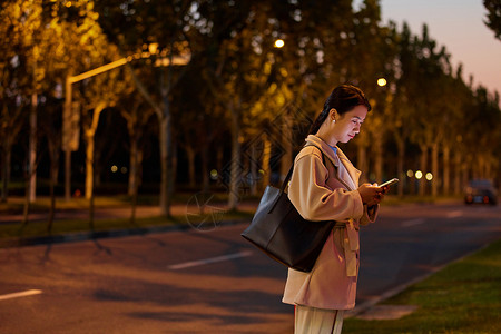 夜间马路年轻女性下班马路旁等待背景