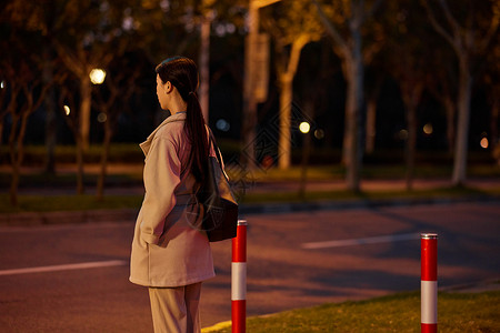 过马路看红绿灯夜晚职场女性下班等红绿灯背景