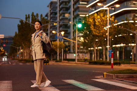 青年女性夜间过马路背景图片