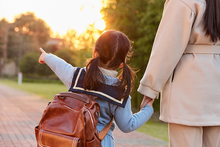 放学回家夕阳下母女牵手回家背影背景