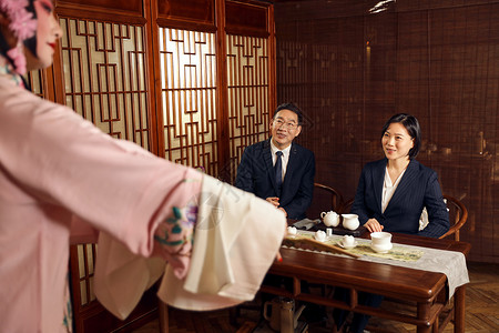 商务人士在戏曲茶楼听戏喝茶中国元素高清图片素材