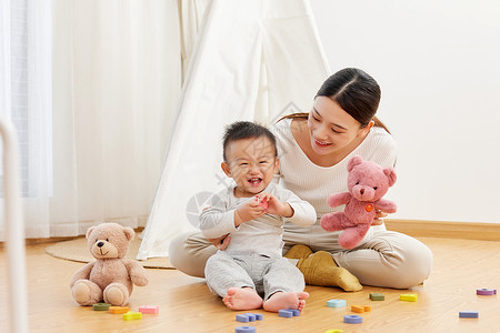 温馨宝宝素材妈妈和孩子坐在地上一起玩耍背景