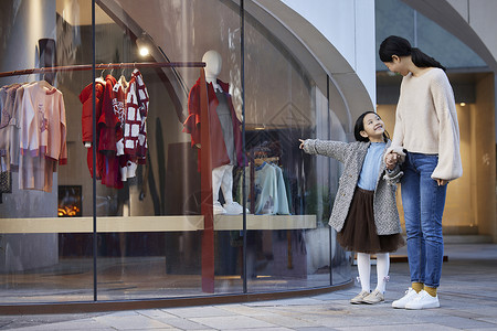 亲子冬季妈妈带女儿逛街买衣服背景