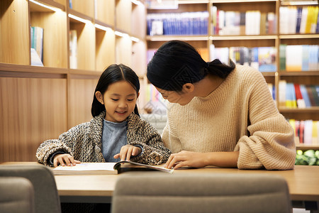 温馨书店温馨母女坐在书店阅读背景