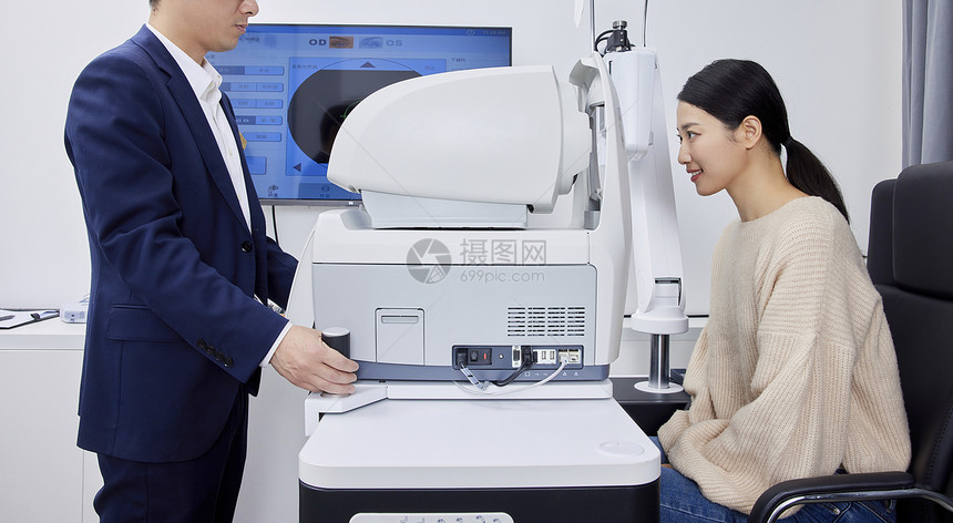 验光师在用专业验光机器给年轻女性检查视力图片