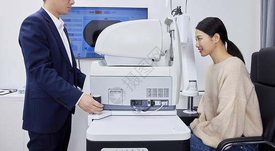 验光师在用专业验光机器给年轻女性检查视力背景图片