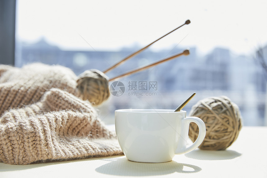 窗前的咖啡杯和针织毛球制品图片