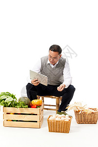 中年男性研究线上售卖蔬菜背景图片