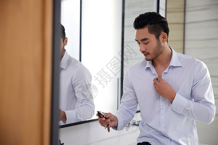 在镜子前看手表的商务男性图片