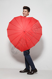 一把打开的雨伞青年男人拿着心形红雨伞背景