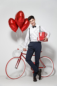 礼物气球爱心庆祝幸福青年男人扶着自行车背景