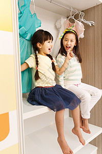 儿童可爱的小女孩坐在衣柜里图片