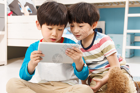 产品活动两个男孩在使用平板电脑背景