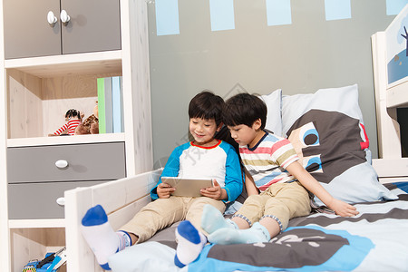 家具产品快乐两个男孩在使用平板电脑背景