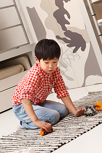 小男孩在地毯上玩耍图片