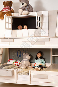 可爱的小女孩在床上玩耍住宅内部高清图片素材