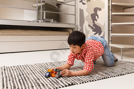 成长小男孩在地毯上玩耍图片