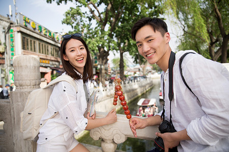 情侣旅游拿着糖葫芦高清图片